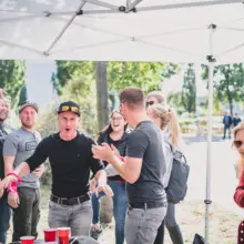 Menschengruppe beim Bierpong