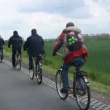 Menschen fahren in einer Reihe hintereinander Fahrrad