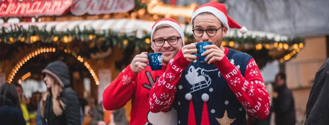 zwei Männer trinken Glühwein auf dem Bonner Weinachtsmarkt