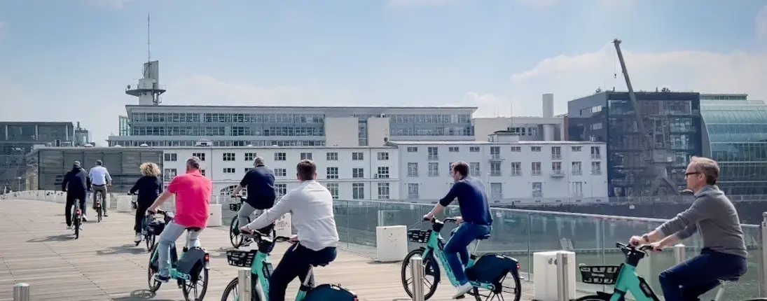 eine Gruppe von Menschen fährt mit dem Fahrrad über eine Brücke