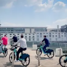 eine Gruppe von Menschen fährt mit dem Fahrrad über eine Brücke