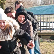 Teilnehmer:innen einer Schnitzeljagd spielen ein Spiel und lachen